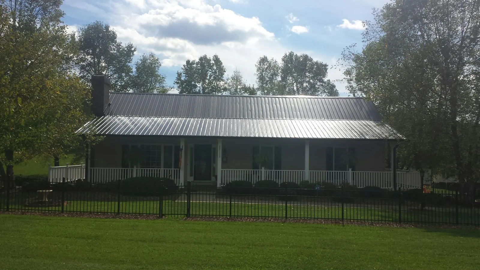 Gray metal roof on a brick ranch with a full width front porch — Gutter Guard Installation work by our crew in Ephrata